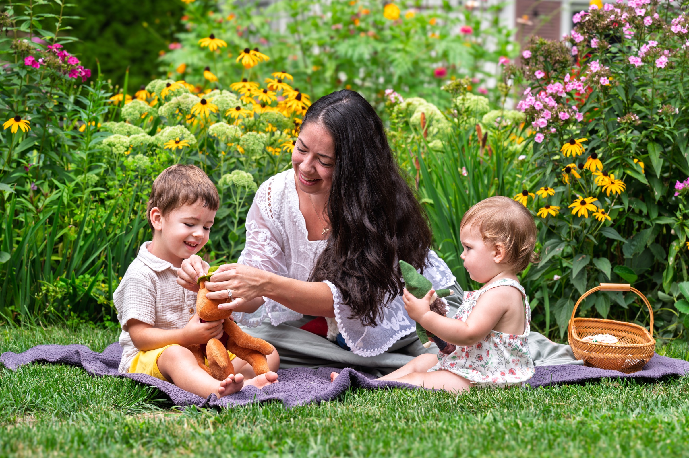 Brooke Kelly making handmade toys with her children in a flower garden.