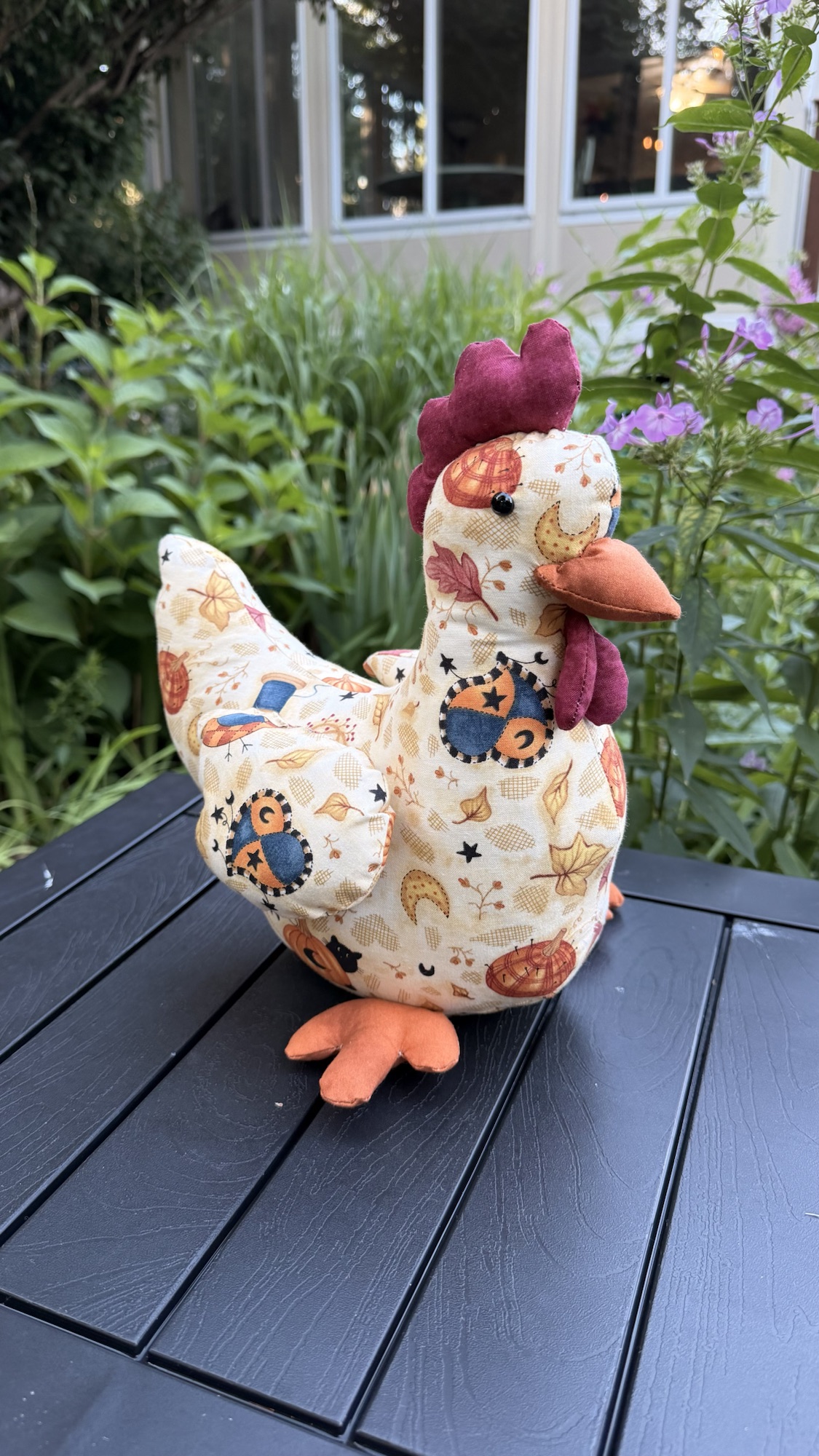 Handmade floral textile chicken with embroidered details.