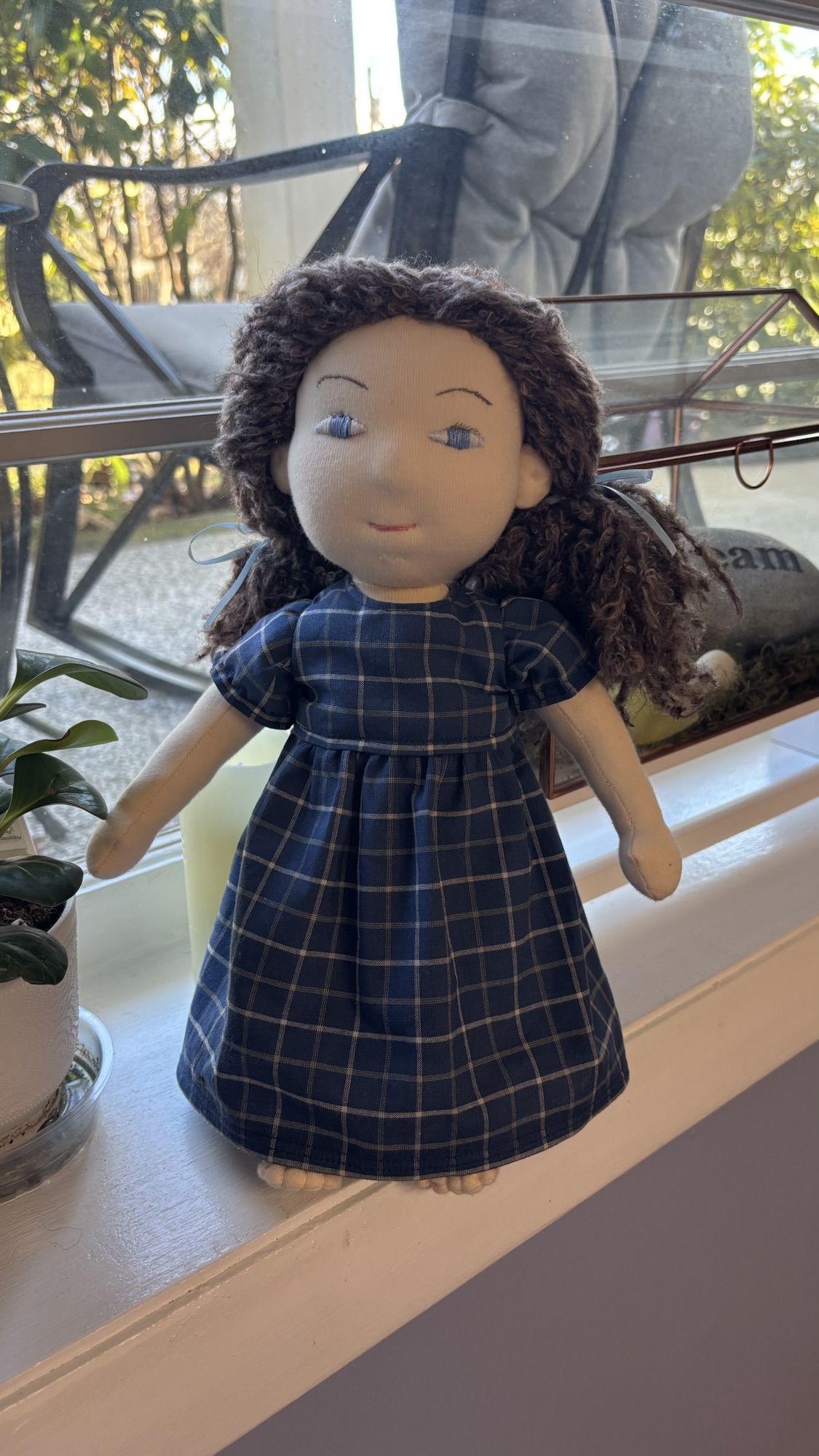 Handmade cloth doll wearing a navy plaid dress.