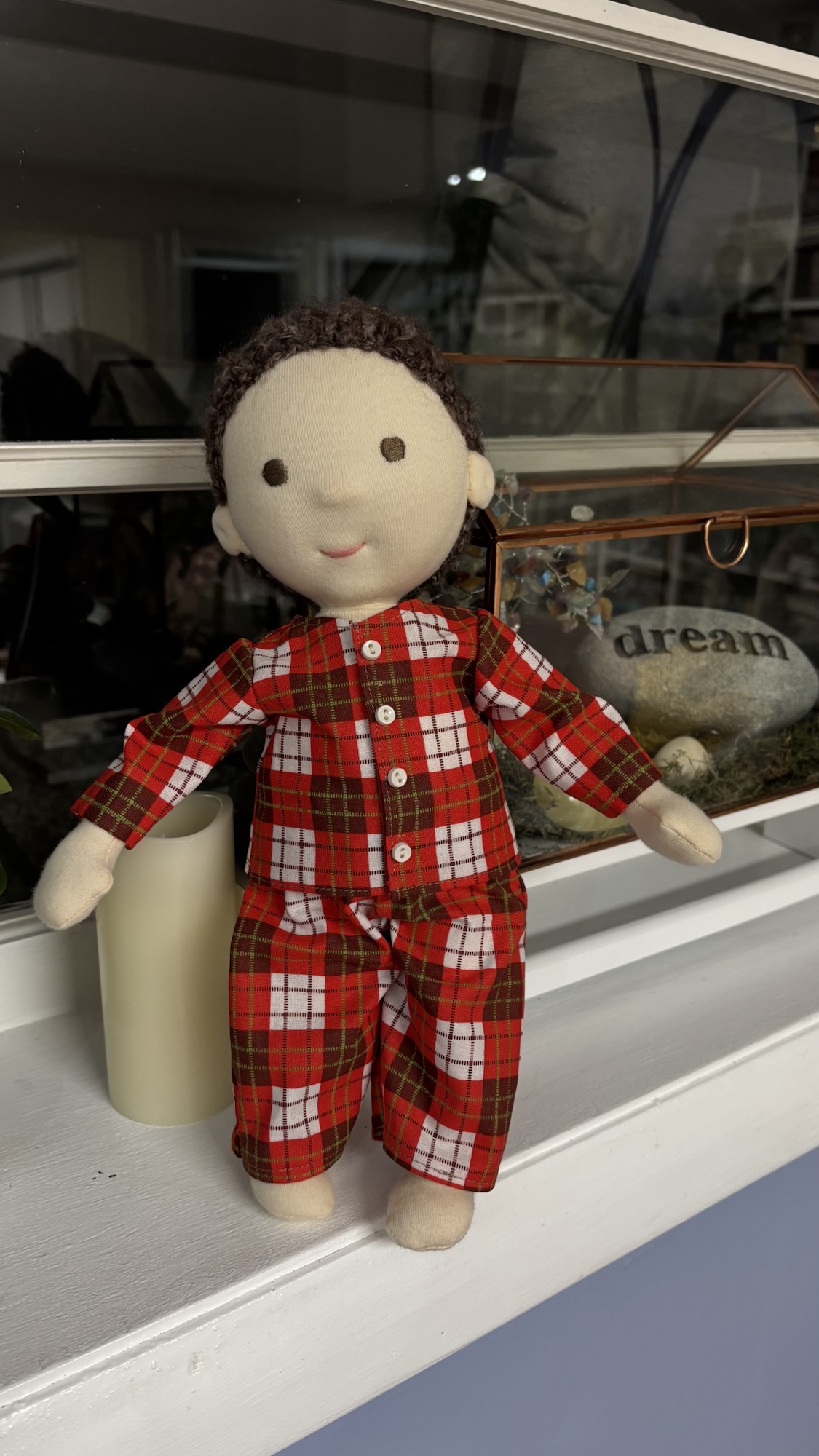 Handmade cloth doll wearing red plaid pajamas.