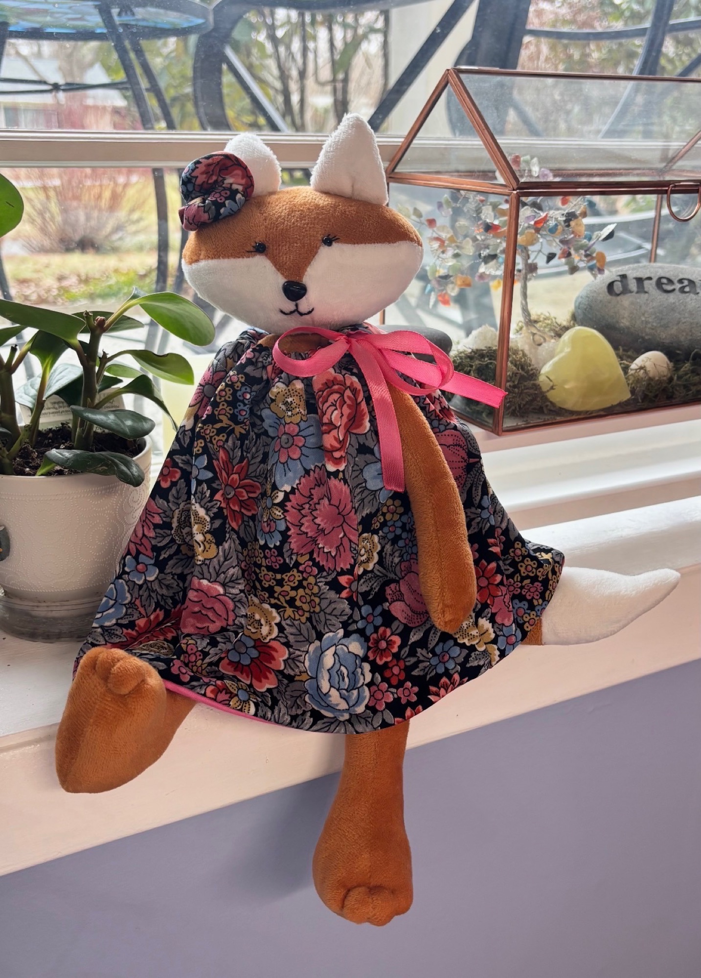 Handmade fox character wearing a dark floral dress with pink ribbon details.